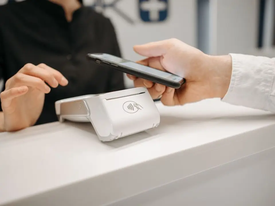 Cliente paga con el teléfono en una terminal de cobro