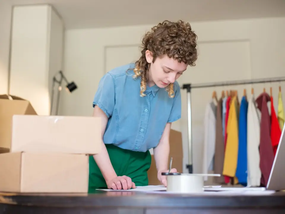 Emprendedora prepara pedidos entre cajas de envío